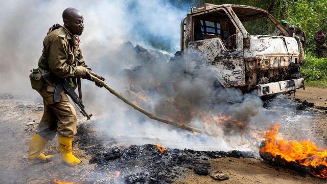 콩고 군인과 유엔군이 2021년 4월 이슬람주의자 공격 현장을 조사하고 있다. 한 소방관이 화재를 진압하는 모습이 보인다.
