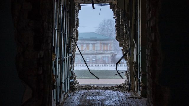 벽에 난 구멍 사이로 승강장과 건물이 보인다. 