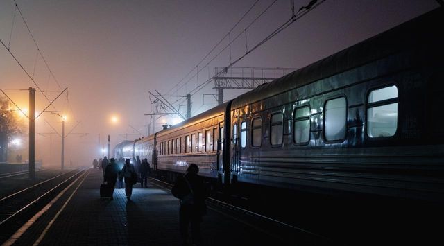 안개 속 승강장에 선 열차와 사람들. 