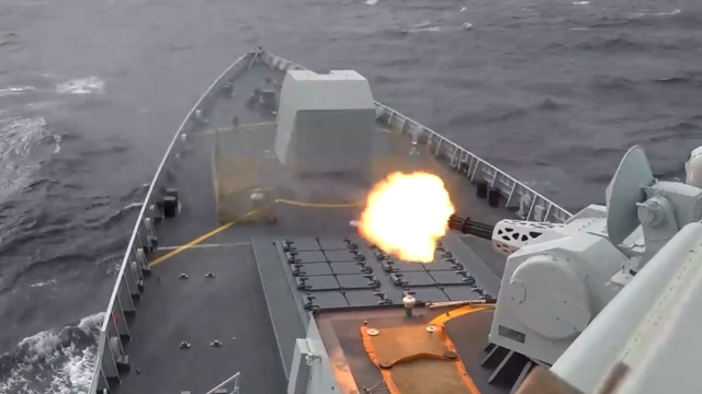 전함 앞부분에서 바다를 향해 포격하는 모습