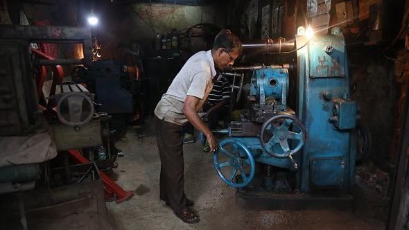 2024년 7월 18일 인도 콜카타의 한 제조 공장에서 한 작업자가 농기계 예비 부품을 만들면서 선반을 조작하고 있다