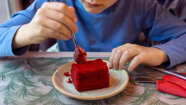 붉은색 케이크를 먹는 아이의 모습