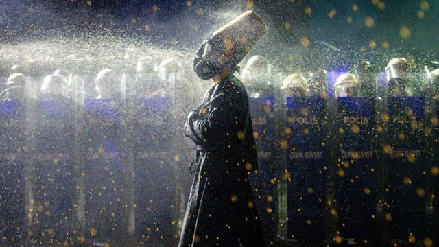 지난 23일 이스탄불에서 방독면을 쓰고 진압 경찰대 앞을 걸어가는 시위대의 모습