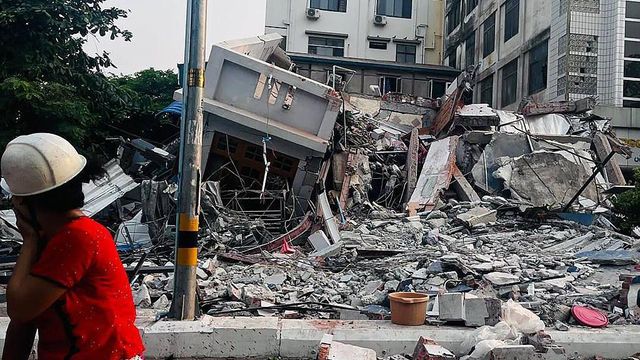 한 주민이 강력한 지진으로 무너진 만달레이의 건물 옆을 걷고 있다