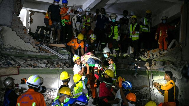 구조대원들이 만달레이의 스카이 빌라 공사 현장에서 생존자를 이송하는 모습