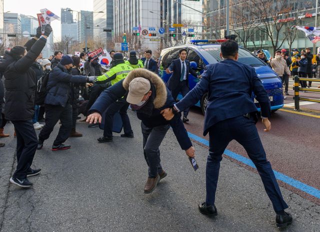 지난 1월 18일 대통령 경호원들과 경찰이 서부지방법원 인근에서 윤석열 대통령을 태운 것으로 추정되는 차량 앞으로 다가가려는 지지자들과 대치하고 있다