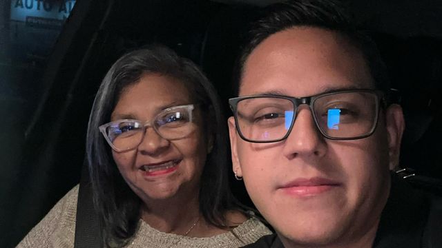 검고 회색 머리의 중년 여성이 안경을 쓰고 머리가 짧은 남성과 함께 웃으며 찍은 사진