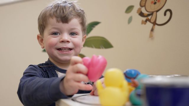  플라스틱 오리를 갖고 노는 유아의 모습