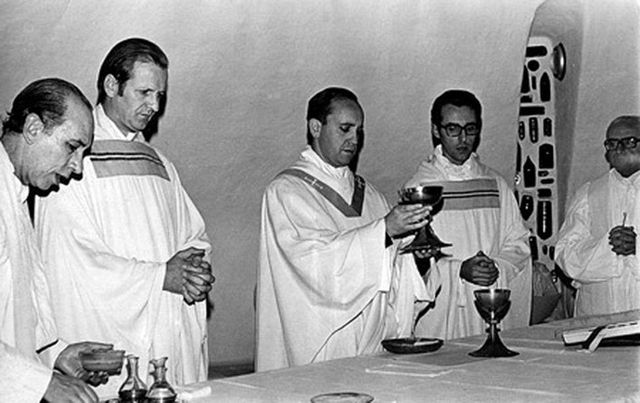 호르헤 마리오 베르고글리오 관구장이 다른 4명의 고위 인사들이 옆에 서 있는 가운데 성찬잔을 들고 있다