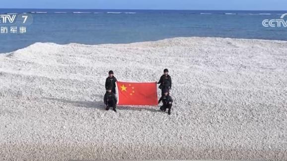 중국 해안경비대원 4명이 중국이 영유권을 주장하는 모래언덕에서 오성홍기를 펼친 모습