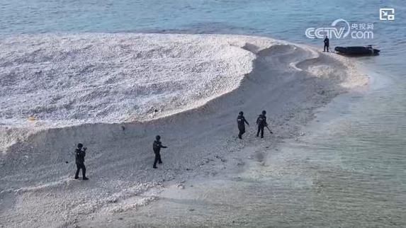 모래톱을 가로질러 해안가에서 대기 중인 보트로 다가서는 중국 해안경비대원의 모습