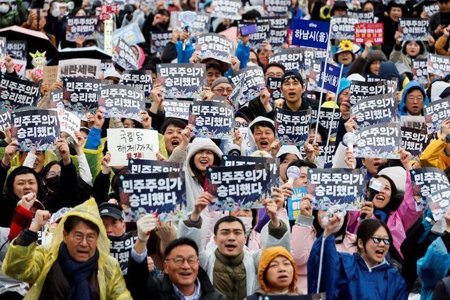 '민주주의가 승리했다' 슬로건을 흔드는 집회 참가자들