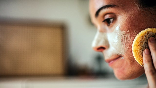 한 여성이 피부에 크림을 바르고 있다