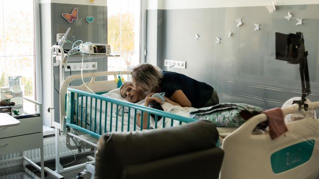 병원 침대에 누운 아들 세르히의 뺨에 입을 맞추는 테티아나 사이엔코