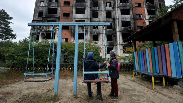 2022년 9월 15일, 키이우 북쪽 칼리니우카의 파괴된 건물 앞 놀이터에 있는 어린이들의 모습