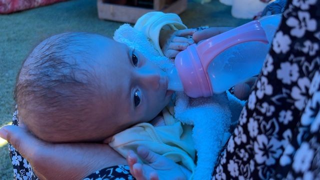 영양실조에 걸린 듯한 아기에게 우유를 먹이는 모습