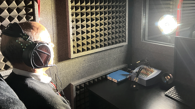  '드림머신' 방음 부스에 앉아 눈을 감고 헤드폰을 착용한 기자의 모습