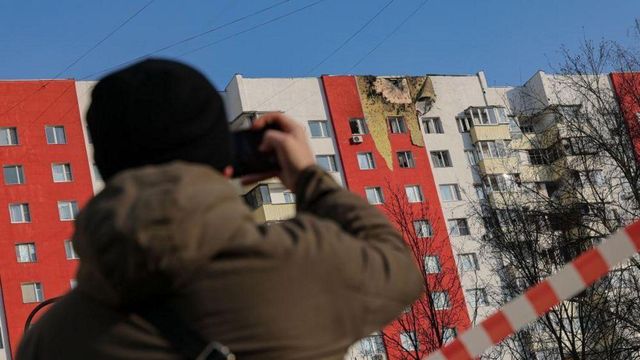 드론 공격을 받은 건물 사진을 찍는 사람