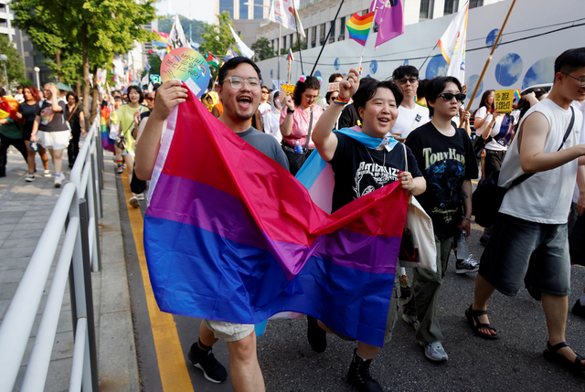 서울퀴어문화축제에서 성소수자와 지지자들이 무지개 깃발을 들고 프라이드 퍼레이드를 행진하고 있다 