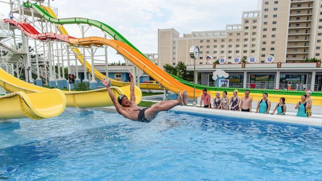 북한 강원도 원산갈마 해안관광지구 명사십리 워터파크에서 국내 관광객들이 한 남성이 미끄럼틀을 타고 수영장으로 들어가는 모습을 지켜보고 있다.