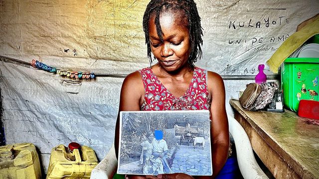 의자에 앉아서 사진을 보여주고 있는 여성