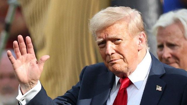 카메라에 손을 흔드는 도널드 트럼프