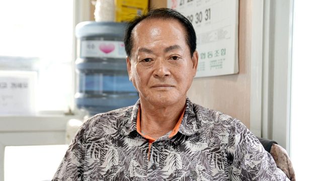 유석술씨가 사무실에 앉아 카메라를 바라보고 있다