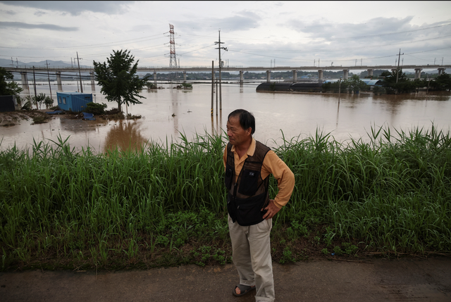 침수된 마을에 침통한 표정을 짓고 있는 한 주민