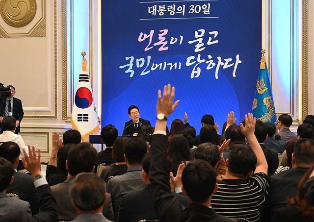 취재진들이 이재명 대통령에게 질의를 하기 위해 손을 들고 있다