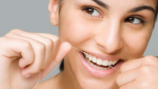 한 여성이 치실을 사용하고 있다