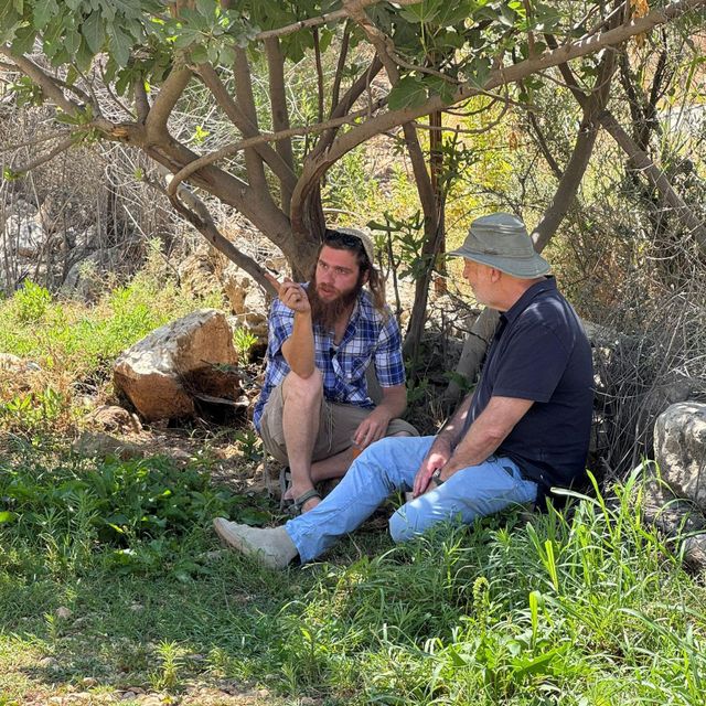 무화과나무 아래 풀밭에 앉아 있는 제레미 보웬과 메이어 심차