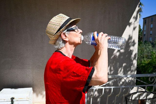 길을 걷다 물을 마시는 남성의 모습