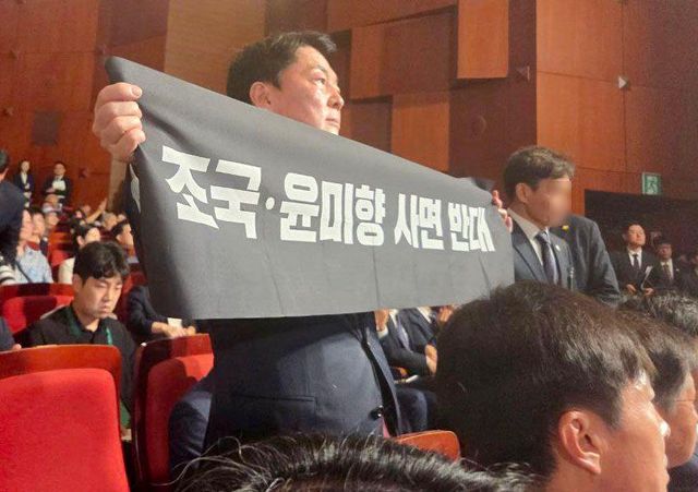 안철수 국민의힘 당대표 후보가 15일 오전 서울 종로구 세종문화회관에서 열린 제80주년 광복절 경축식에 참석해 경축사 중인 이재명 대통령을 향해 조국 전 조국혁신당 대표와 윤미향 전 의원의 사면 반대 플래카드를 들어보이며 항의하고 있다