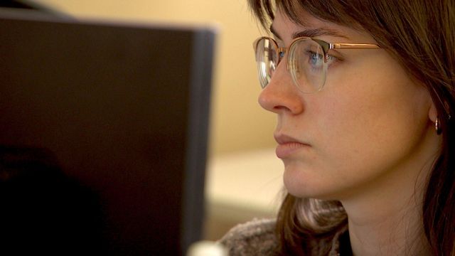 컴퓨터 화면을 보고 있는 여성의 모습