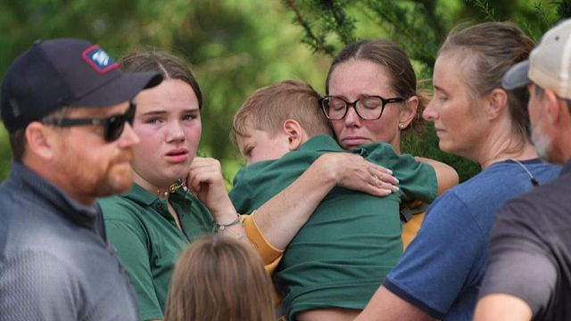 슬픈 표정으로 아들을 안고 있는 가족들의 모습