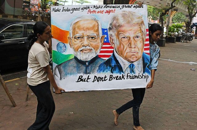 인도 뭄바이의 한 학교 밖에서 학생들이 도널드 트럼프 미국 대통령과 나렌드라 모디 인도 총리가 함께 담긴 포스터를 들고 있다.