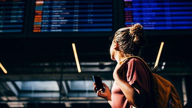 공항에서 비행기 출도착 전광판을 바라보는 여성