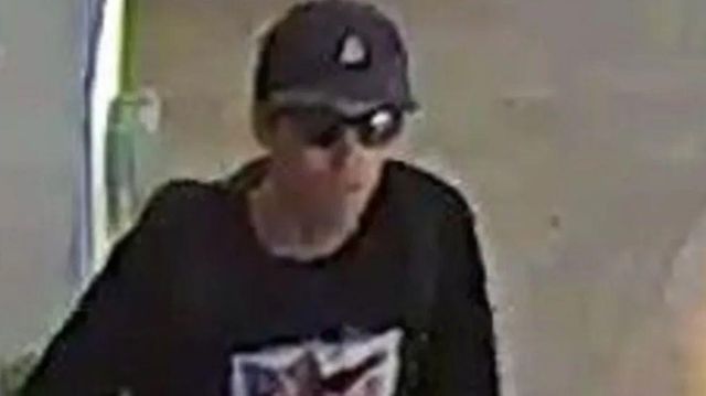 모자와 선글라스를 착용하고, 파란색 셔츠를 입은 남성의 모습