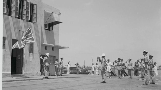 영국 해군이 벽면의 국기를 내리는 모습