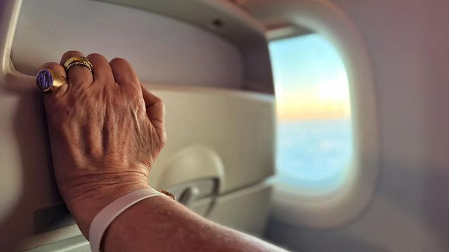 비행기 앞 좌석을 꽉 잡고 있는 노인의 손