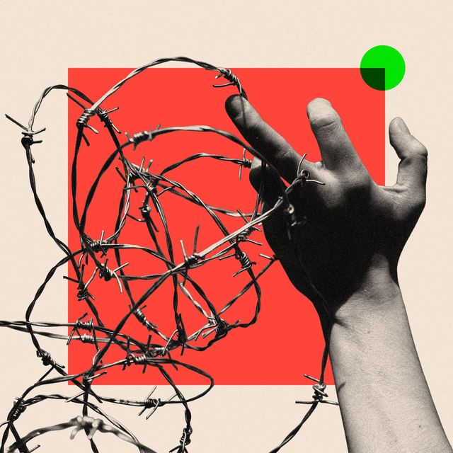 A hand holding barbed wire