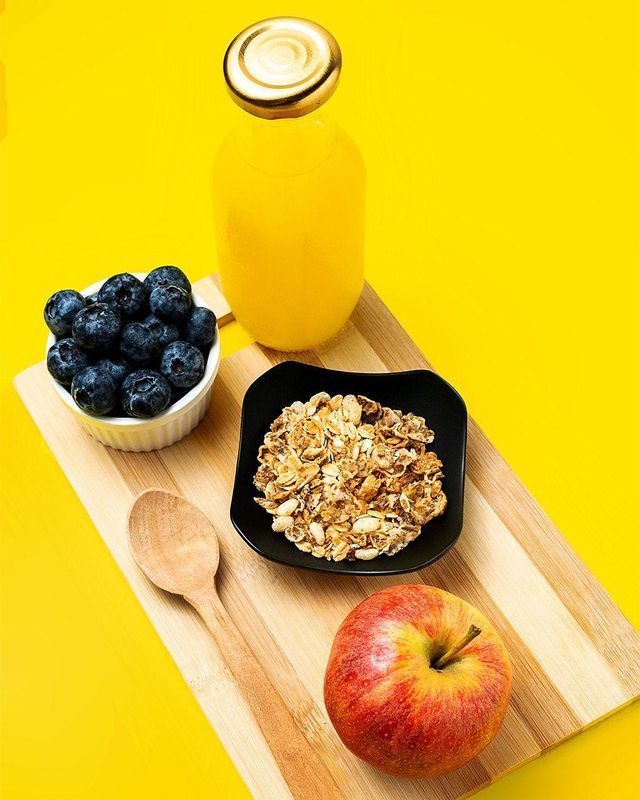 오렌지 주스, 블루베리, 씨리얼, 사과가 놓여있다