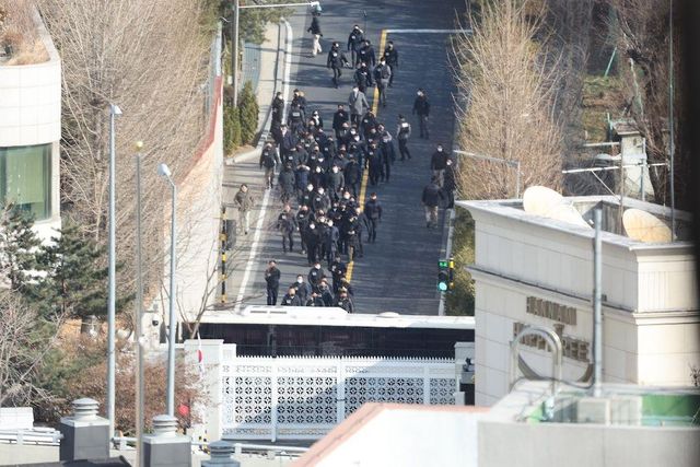 한남동 대통령 관저에서 이동하는 수십 명의 사람들