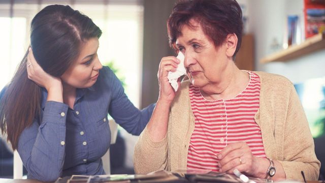 눈물을 흘리는 나이든 여성을 위로하는 젊은 여성의 모습