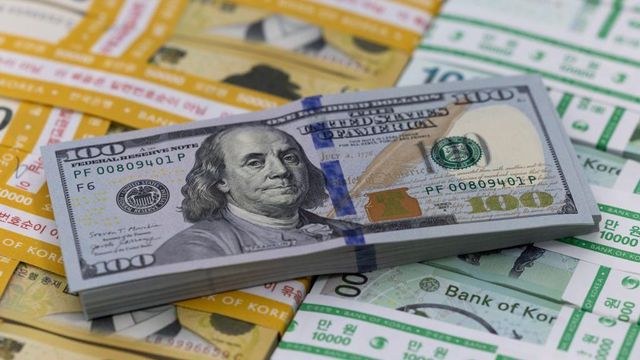 한국의 오만원권과 만원권 지폐 위로 미국의 백달러 지폐 뭉치가 올려져 있다