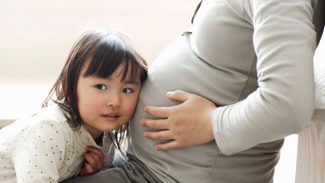 임신한 엄마의 배에 귀를 기울이고 있는 아이의 모습