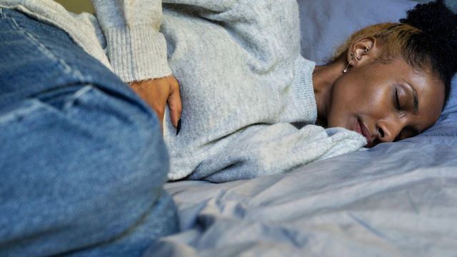 아랫배를 움켜쥐고 있는 여성