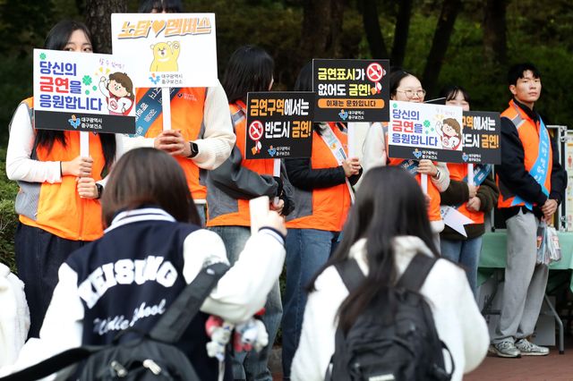 대구 중구 계성중학교에서 중구보건소와 중구청 관계자들이 등굣길 학생들을 대상으로 '청소년 금주·금연 캠페인'을 펼치고 있다. '당신의 금연을 응원합니다', '금연표시가 없어도 금연'이라는 피켓을 든 사람들 사이로 교복을 입은 여학생들이 지나가고 있다