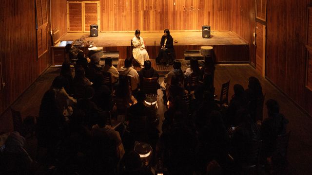 좁은 공간에서 여성 2명의 글 낭독을 경청하는 소수의 청중들