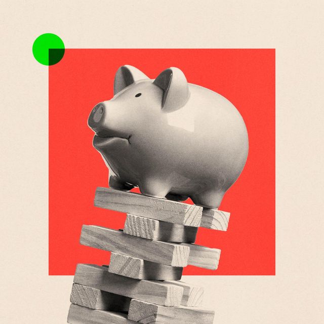 흔들리는 나무 블록 위에 위태롭게 놓여 있는 돼지 저금통